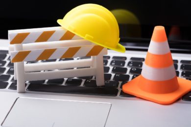 Road,Barrier,With,Hard,Hat,And,Traffic,Cone,On,Laptop