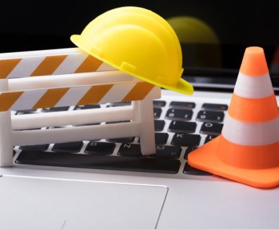 Road,Barrier,With,Hard,Hat,And,Traffic,Cone,On,Laptop