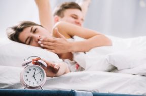 couple-waking-up-near-alarm-clock-with-5am_23-2148027349