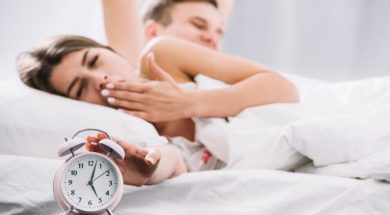 couple-waking-up-near-alarm-clock-with-5am_23-2148027349