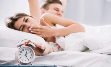 couple-waking-up-near-alarm-clock-with-5am_23-2148027349