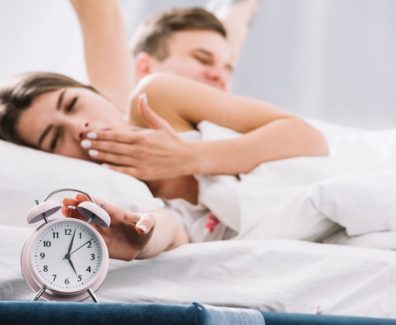 couple-waking-up-near-alarm-clock-with-5am_23-2148027349