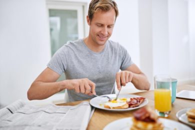 food-eating-breakfast-man-with-newspaper-relax-morning-with-smile-balanced-diet-wellness-home-hungry-person-brunch-healthy-nutrition-with-eggs-bread-bacon-protein_590464-365370