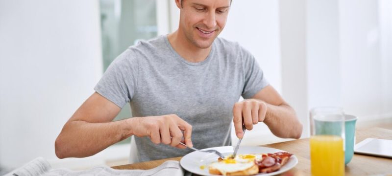 food-eating-breakfast-man-with-newspaper-relax-morning-with-smile-balanced-diet-wellness-home-hungry-person-brunch-healthy-nutrition-with-eggs-bread-bacon-protein_590464-365370