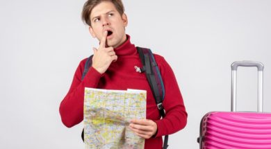 front-view-male-tourist-with-backpack-map-white-wall_179666-28730