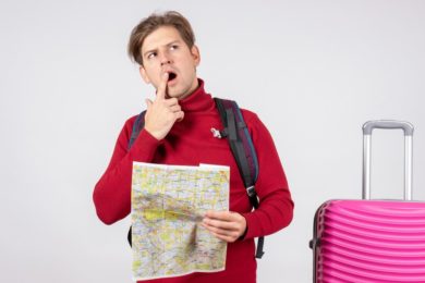 front-view-male-tourist-with-backpack-map-white-wall_179666-28730