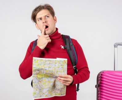 front-view-male-tourist-with-backpack-map-white-wall_179666-28730