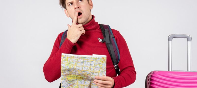 front-view-male-tourist-with-backpack-map-white-wall_179666-28730